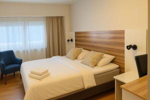 a hotel room with a bed and a blue chair at Arkadia Hotelli in Helsinki