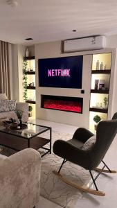 a living room with a netflix sign on the wall at غرفتين نوم مع صاله دخول ذاتي in Quai +7 photos