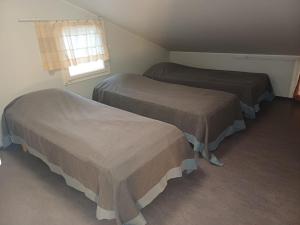 En eller flere senge i et værelse på Lomahuoneisto paritalossa Puustila B