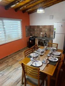 埃普延Fh alojamiento的厨房里一张木桌,上面放有盘子和碗