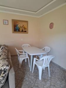 uma sala de jantar com uma mesa, cadeiras e um sofá em Casa Feliz em Cascavel