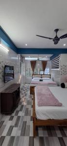 a large bedroom with two beds and a television at Cloud Mist Inn YERCAUD in Yercaud