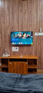 a flat screen tv on a wooden wall at Cloud Mist Inn YERCAUD in Yercaud