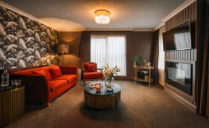 un soggiorno con un divano arancione e una TV di The Fairview Boutique Hotel a Killarney
