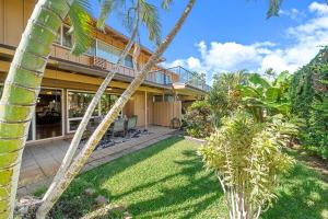 an exterior view of a house with palm trees at Puamana 153-4 · PU 153-4 Spacious Puamana Unit & Walk To The Bea in Lahaina