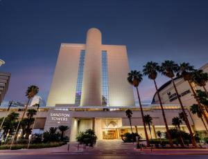 um grande edifício com palmeiras na frente em Sandton Sun and Towers em Joanesburgo