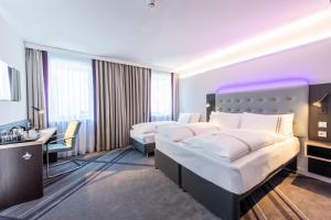 a hotel room with two beds and a desk at Premier Inn Passau Weisser Hase in Passau +10 photos