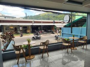 un restaurant avec deux tables et des chaises ainsi qu'une fenêtre dans l'établissement THE NICE, à Patong Beach