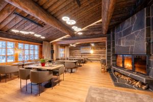 a restaurant with tables and chairs and a fireplace at Saariselkä Kelo Lodge in Saariselka +37 photos