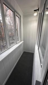 Una habitación con dos ventanas y ducha a ras de suelo. en Люкс 2х комнатная квартира, en Taraz