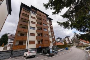 a white car parked in front of a building at Apartman Vida Zlatibor in Zlatibor