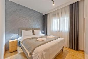 a bedroom with a large bed with a gray wall at Apartman Vida Zlatibor in Zlatibor +14 photos