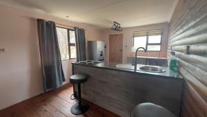 a kitchen with a counter with a sink and a refrigerator at Maun HideOut in Maun Airport