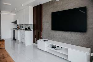 a living room with a television on a wall at Golf View Apartment-AP4 in Maputo