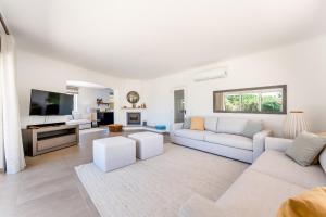 un soggiorno con mobili bianchi e TV a schermo piatto di Villa Benjamin - Vale do Lobo a Vale do Lobo