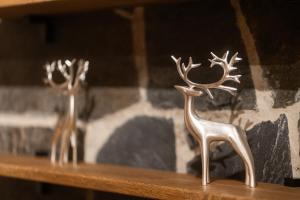 two metal deer statues sitting on a wooden table at Saariselkä Kelo Lodge in Saariselka