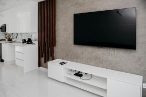 Una sala de estar con un televisor de pantalla plana en una pared. en Golf View Apartment-AP4, en Maputo 6 fotos más