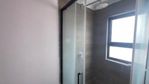 a shower with a glass door in a bathroom at Maun HideOut in Maun Airport +7 photos