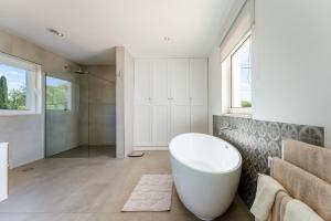 a bathroom with a white tub and a shower at Villa Benjamin - Vale do Lobo in Vale do Lobo +71 photos