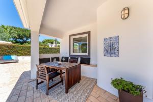 un patio con tavolo e sedie in legno di Villa Benjamin - Vale do Lobo a Vale do Lobo
