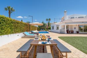 un cortile con tavolo e piscina di Villa Benjamin - Vale do Lobo a Vale do Lobo