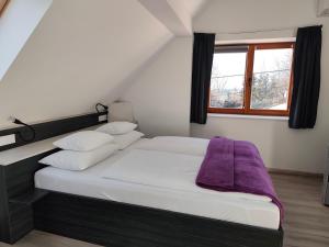 um quarto com uma cama com um cobertor roxo em Darázshegyi Panzió gluténmentes félpanzióval is em Mátraszentimre