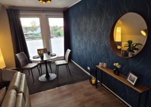 a living room with a table and a mirror at Ferienwohnung Neckel Hohnstorf in Hohnstorf
