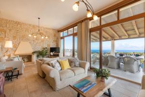 a living room with a couch and a table at Triade IONICA Villas by Rodostamo Collection in Kassiopi