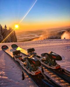 OrličkyにあるKramářova chataの雪に覆われた斜面の上に置かれたスキー板の束