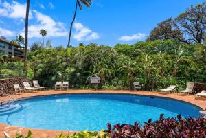 a swimming pool at a resort with chairs and trees at Kaanapali Plantation 57 · KPL 57 Hillside Haven | AC + BeachView in Lahaina