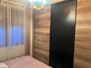 ein Schlafzimmer mit einem schwarzen Kleiderschrank und einem Kronleuchter in der Unterkunft Aurea Vista in Kupres