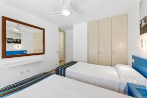 una camera da letto con due letti e uno specchio di Apartamento FORESTA 6 a San Bartolomé