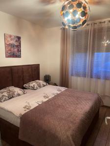 ein Schlafzimmer mit einem Bett und einem Kronleuchter in der Unterkunft Aurea Vista in Kupres