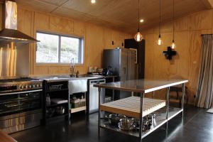 a kitchen with a refrigerator and a table in it at Tractor Shed in Lake Tekapo