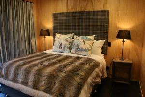 a bedroom with a large bed with pillows and two lamps at Tractor Shed in Lake Tekapo