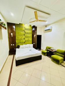 una camera da letto con un letto e una parete verde di Hotel Pak Continental Multan a Multan