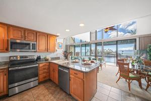 a kitchen with wooden cabinets and a large window at Napili Point C22 · NP C22 Oceanfront Views from 2BD West Maui Co in Lahaina