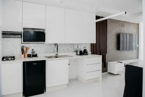 a kitchen with white cabinets and a black refrigerator at Golf View Apartments-AP5 in Maputo