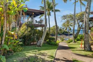 a walkway leading to a house with palm trees at Napili Point C22 · NP C22 Oceanfront Views from 2BD West Maui Co in Lahaina