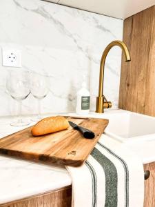 a cutting board with a knife and wine glasses on a counter at IMROF - Mountain Lodge in Escarrilla