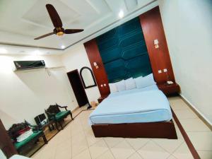 una camera da letto con un letto e un ventilatore a soffitto di Hotel Pak Continental Multan a Multan Altre 23 foto