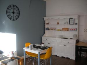 una cucina con tavolo e due sedie gialle di Morlea Guest House a Llandudno Altre 34 foto