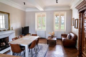 a living room with a wooden table and chairs at Le château in Souvigny
