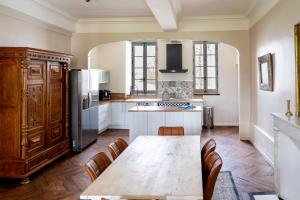 a kitchen with a table and a refrigerator at Le château in Souvigny