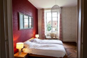 a bedroom with a large bed and a red wall at Le château in Souvigny +29 photos