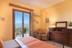 a bedroom with a bed and a television and a balcony at Triade IONICA Villas by Rodostamo Collection in Kassiopi +83 photos