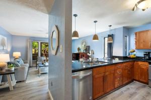 a kitchen and living room with blue walls at Kihei Resort 127 · KRS 127 Relaxing 1BD Condo w AC Pool Beach Ne in Kihei