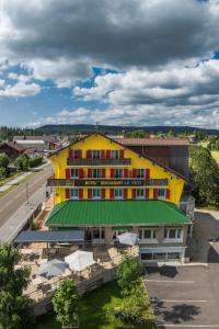 Una vista aérea de un edificio amarillo con techo verde. en Hotel Restaurant LE YETI, en Les Rousses
