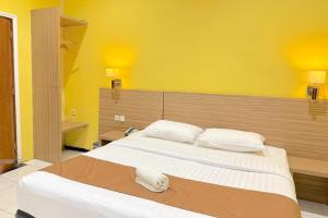 巴图Pondok Jatim Park Hotel & Café的卧室里有一张大床，墙壁是黄色的。