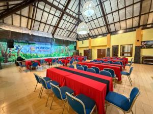 巴图Pondok Jatim Park Hotel & Café的宴会厅配有红色桌子和蓝色椅子 更多23张照片